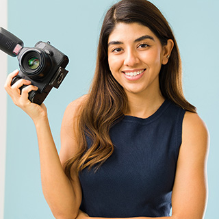 A young woman holding a camera.